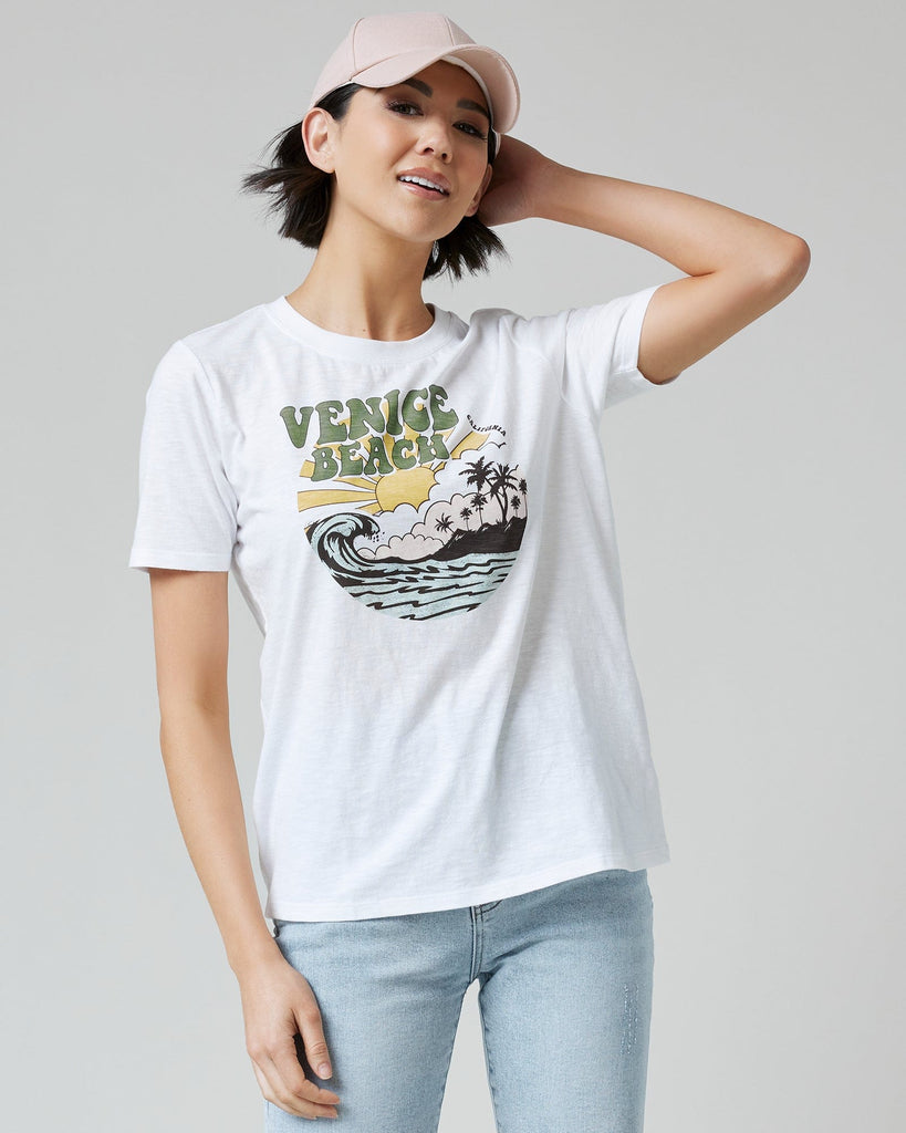 Woman in a white graphic tee with "Venice Beach" on front