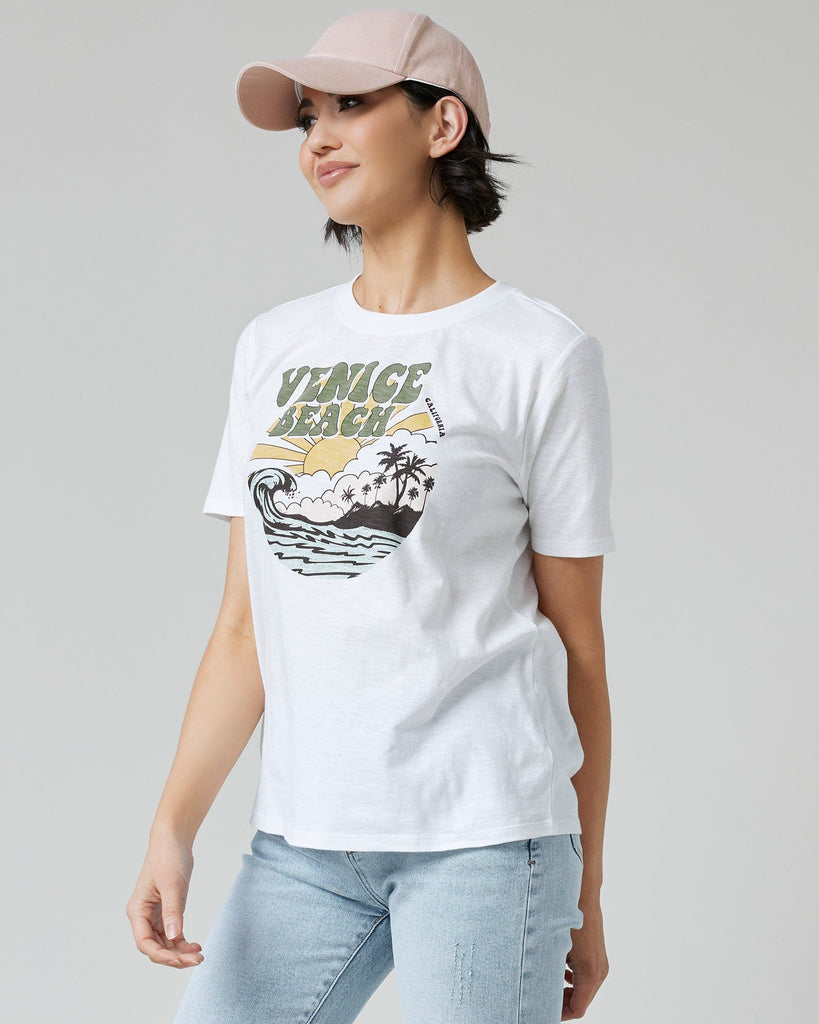 Woman in a white graphic tee with "Venice Beach" on front