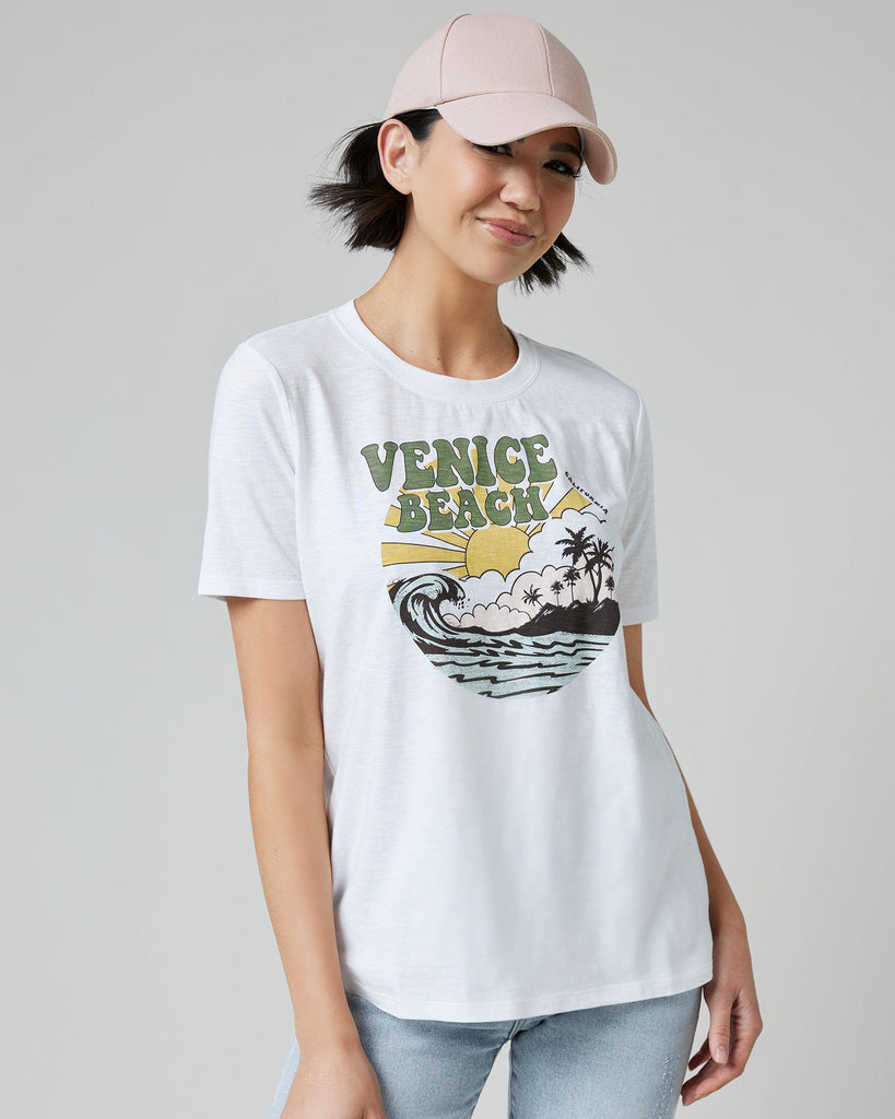 Woman in a white graphic tee with "Venice Beach" on front