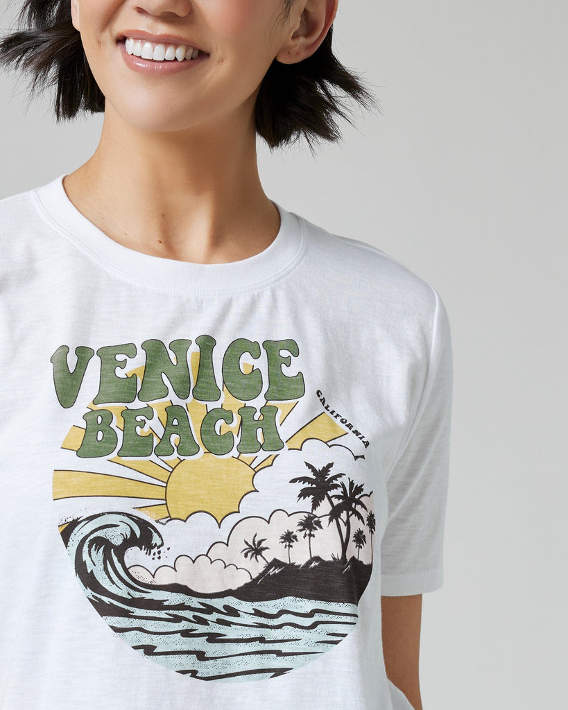 Woman in a white graphic tee with "Venice Beach" on front