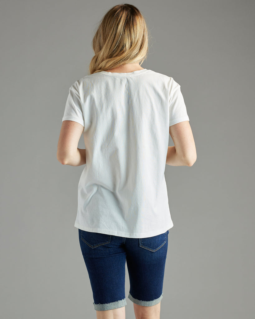 Woman in a white t-shirt with short sleeves and a crochet patch on chest