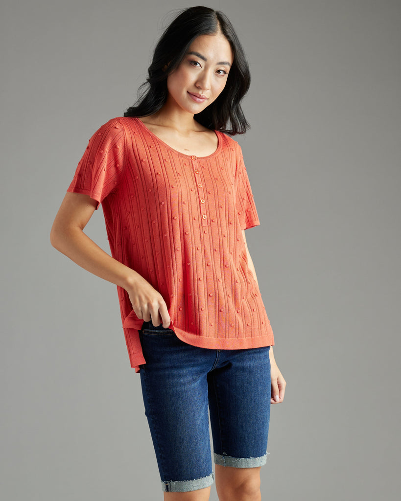 Woman in orange short sleeve textured sweater