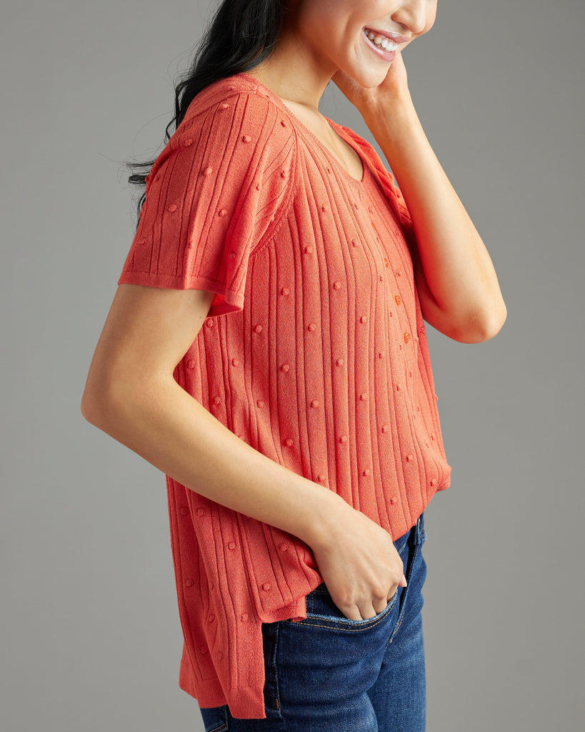 Woman in orange short sleeve textured sweater