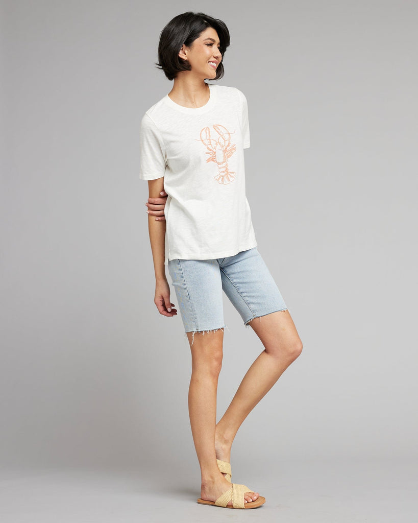 Woman in a white short sleeved graphic tee with a lobster on the front