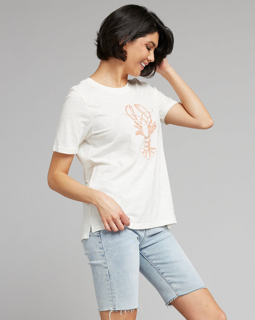 Woman in a white short sleeved graphic tee with a lobster on the front