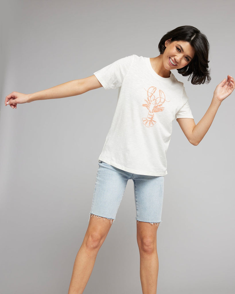 Woman in a white short sleeved graphic tee with a lobster on the front