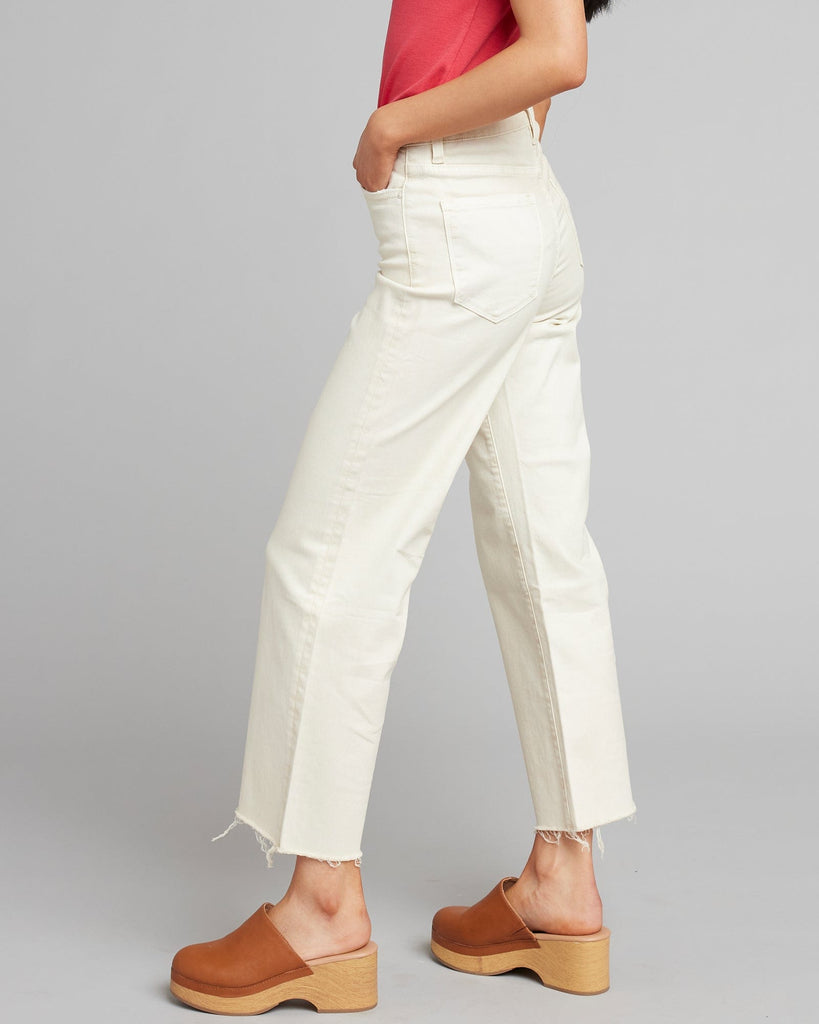 Woman in white high rise cropped denim pants.