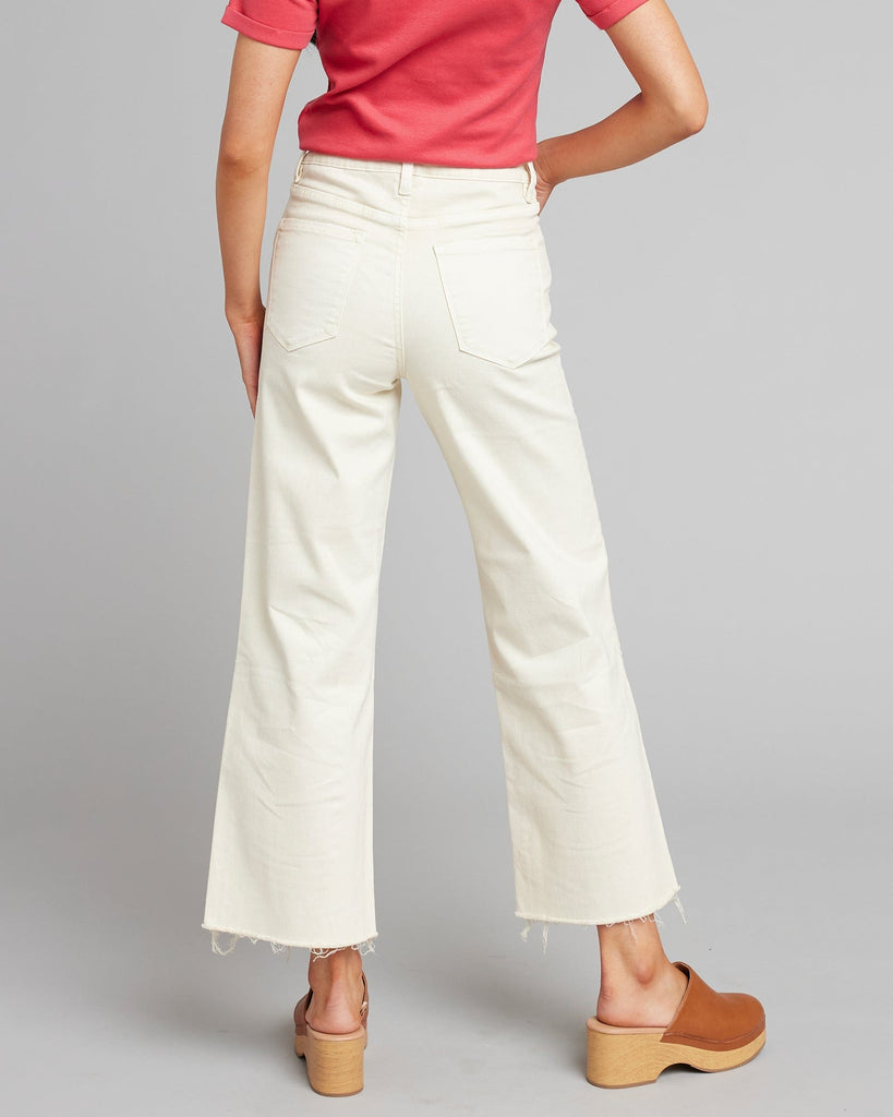 Woman in white high rise cropped denim pants.