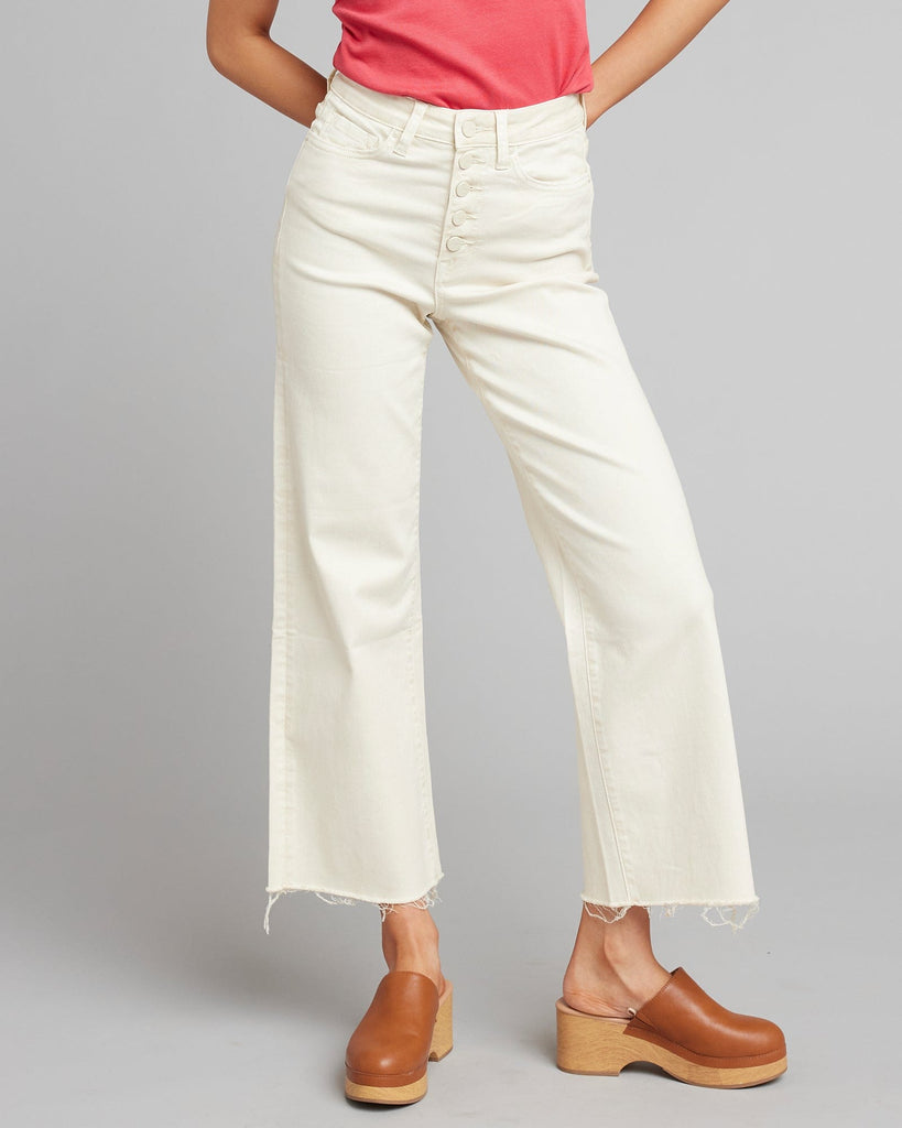 Woman in white high rise cropped denim pants.