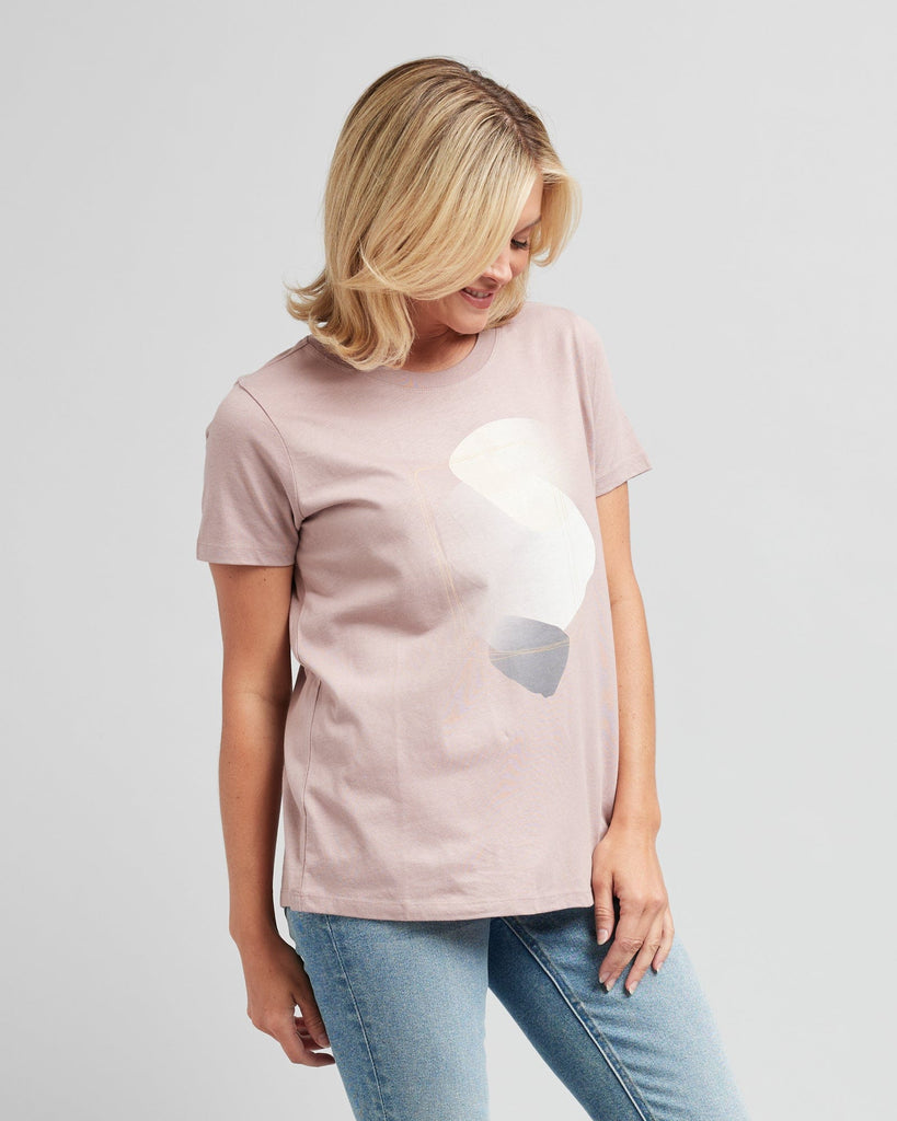 Woman in a short sleeve, pink graphic tee with a silver design on front