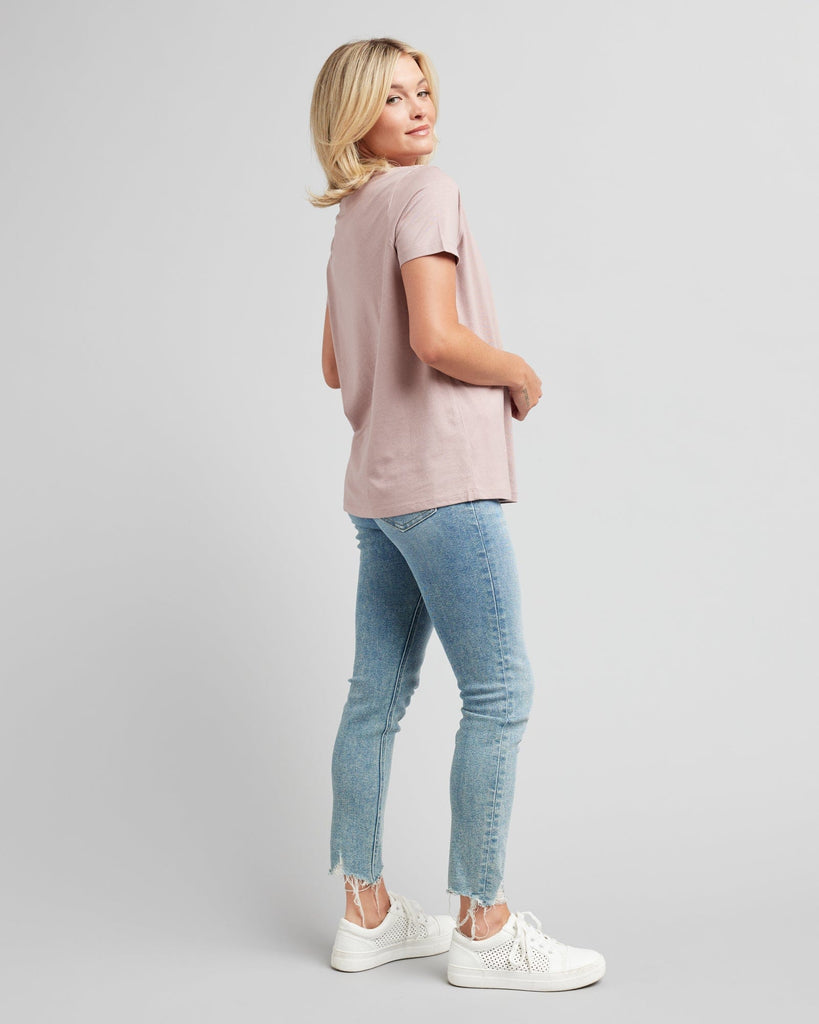 Woman in a short sleeve, pink graphic tee with a silver design on front