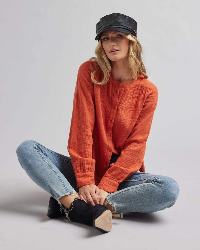 Woman in a long sleeve, orange, textured blouse