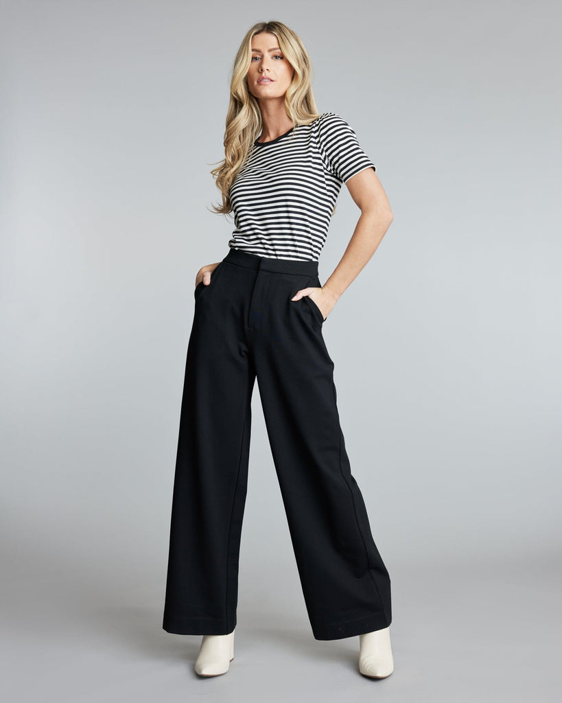 Woman in floor length black pants