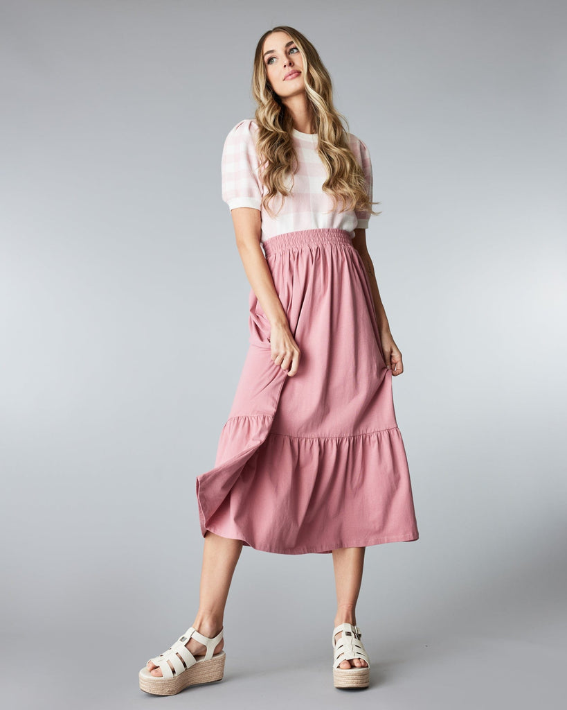 Woman in a pink, tiered, midi skirt