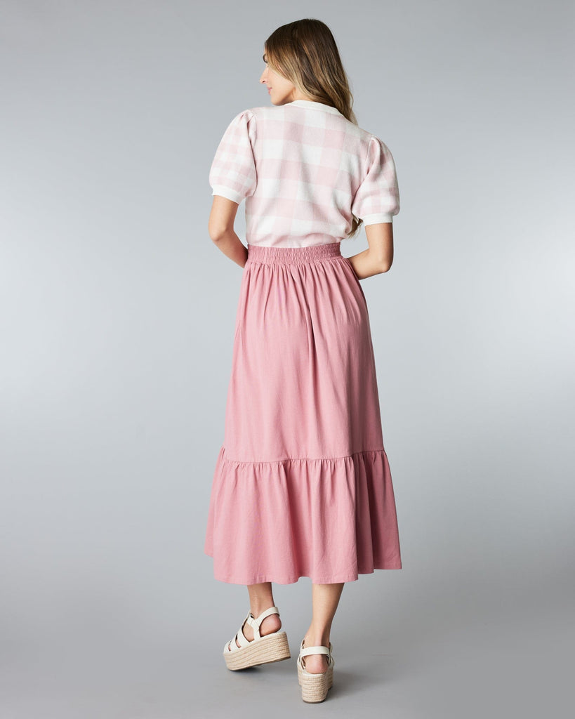 Woman in a pink, tiered, midi skirt