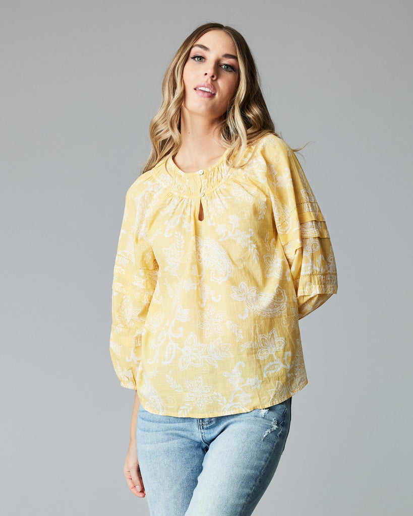 Woman in a 3/4 sleeve, yellow blouse.