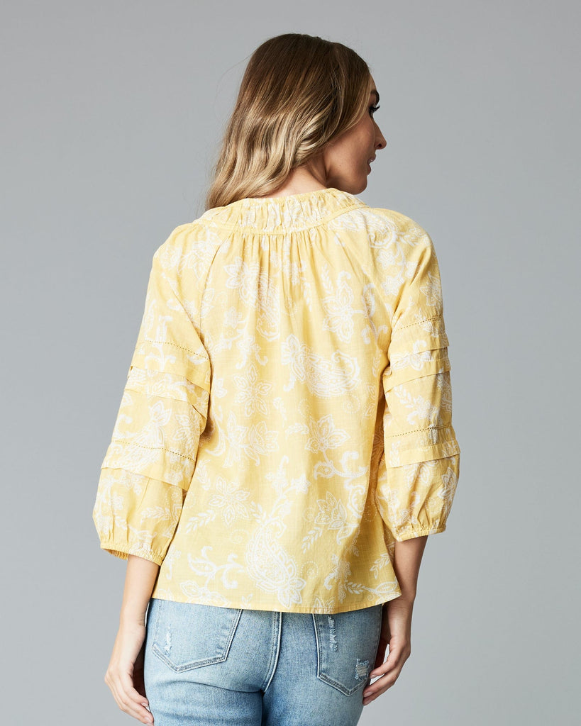 Woman in a 3/4 sleeve, yellow blouse.