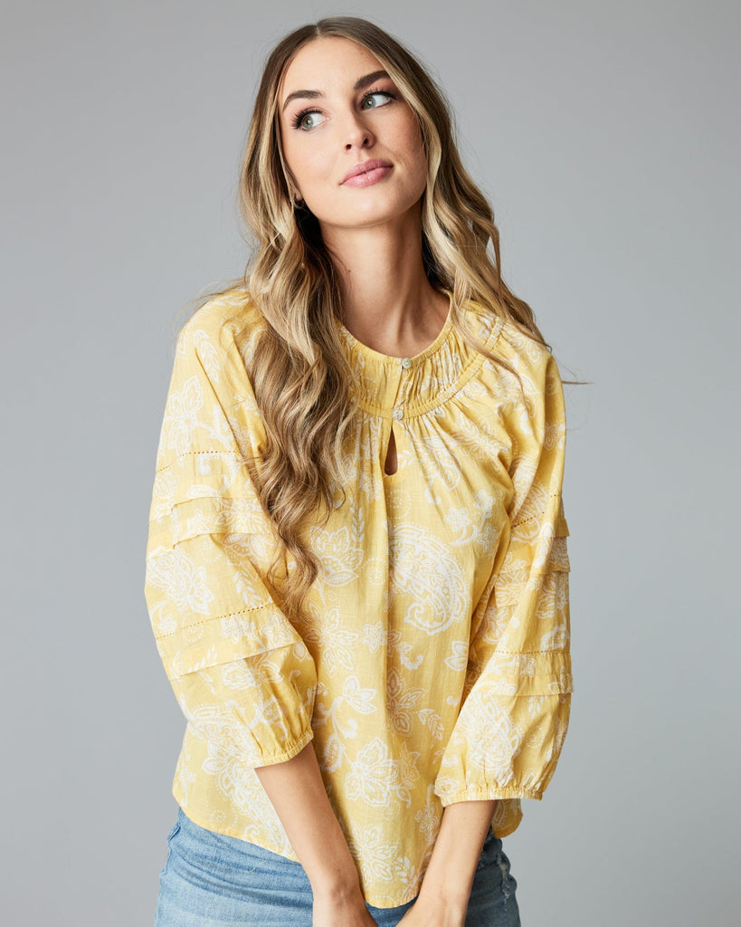 Woman in a 3/4 sleeve, yellow blouse.