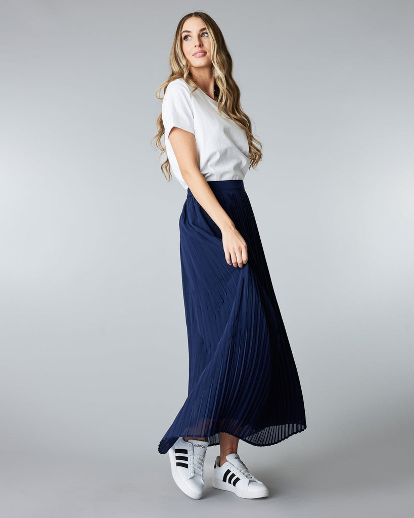 Woman in a maxi length, navy, pleated skirt