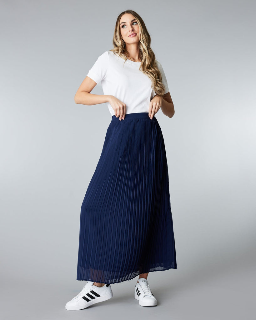 Woman in a maxi length, navy, pleated skirt