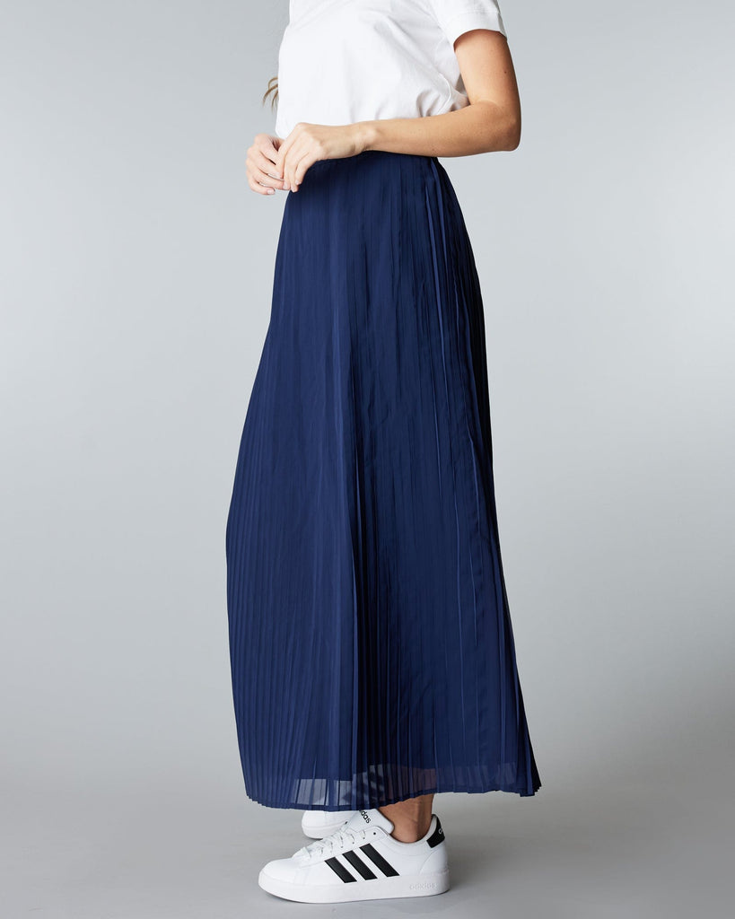 Woman in a maxi length, navy, pleated skirt