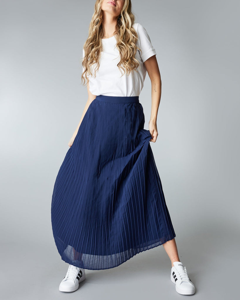 Woman in a maxi length, navy, pleated skirt