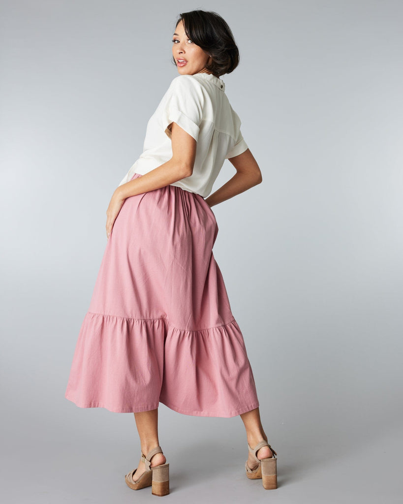 Woman in a pink, tiered, midi skirt