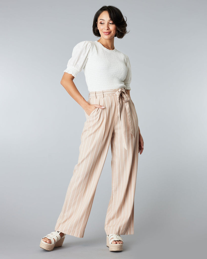 Woman in tan and white striped trousers