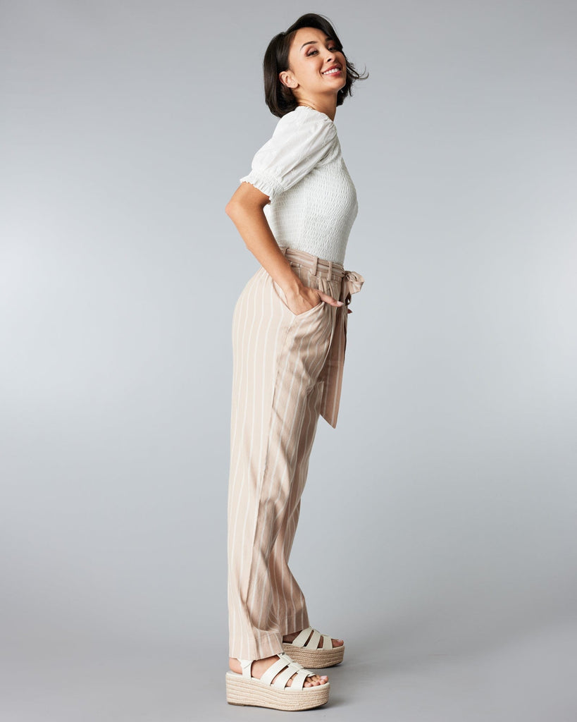 Woman in tan and white striped trousers