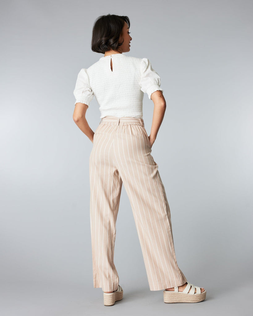 Woman in tan and white striped trousers