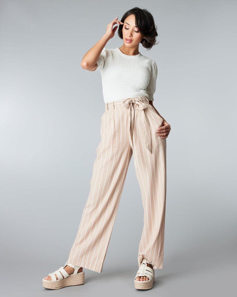 Woman in tan and white striped trousers