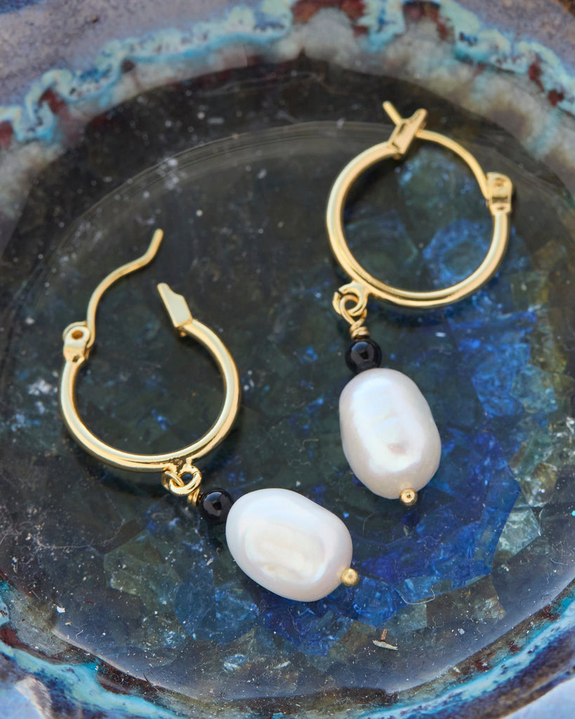 Gold hoop earrings with pearl bead. 