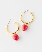 Gold hoop earrings with red strawberry-shaped charms on a white background
