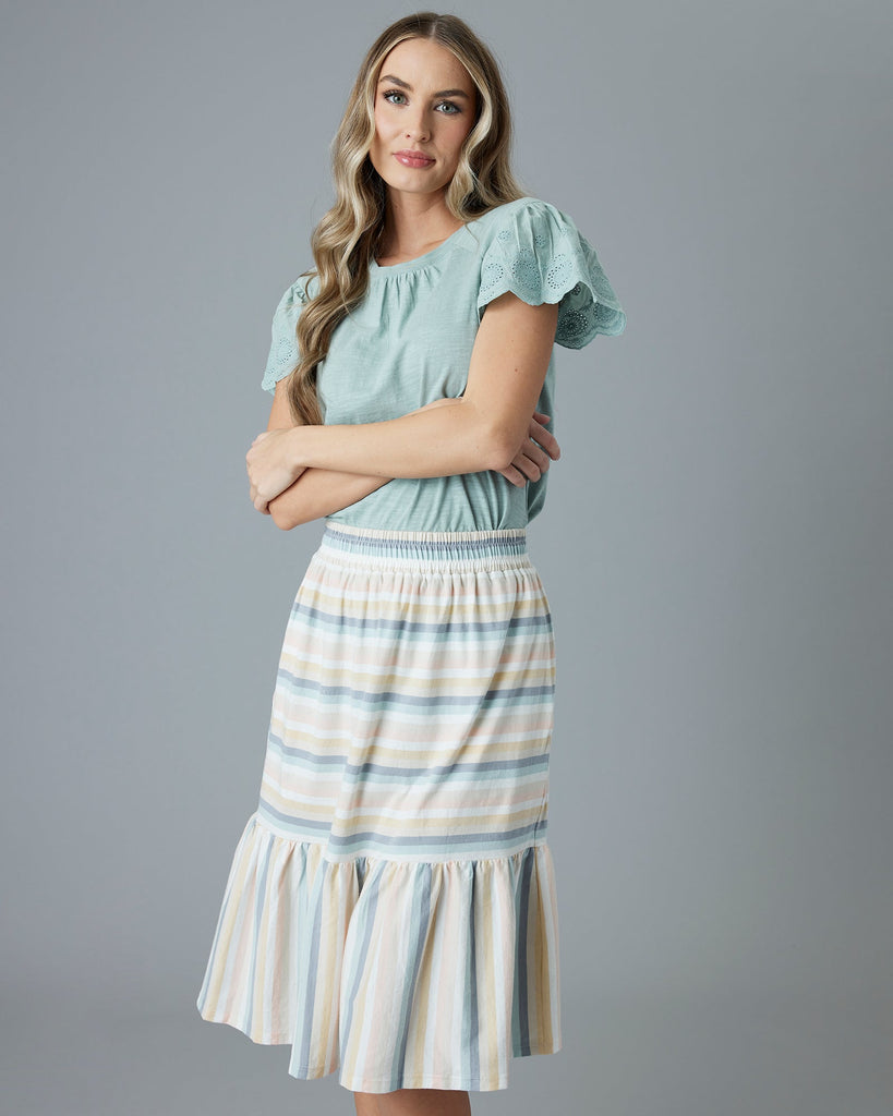 Woman in a pastel rainbow knee-length skirt