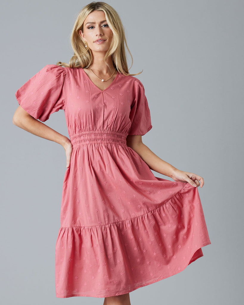 Woman in a rose color, embroidered, short sleeve knee-length dress