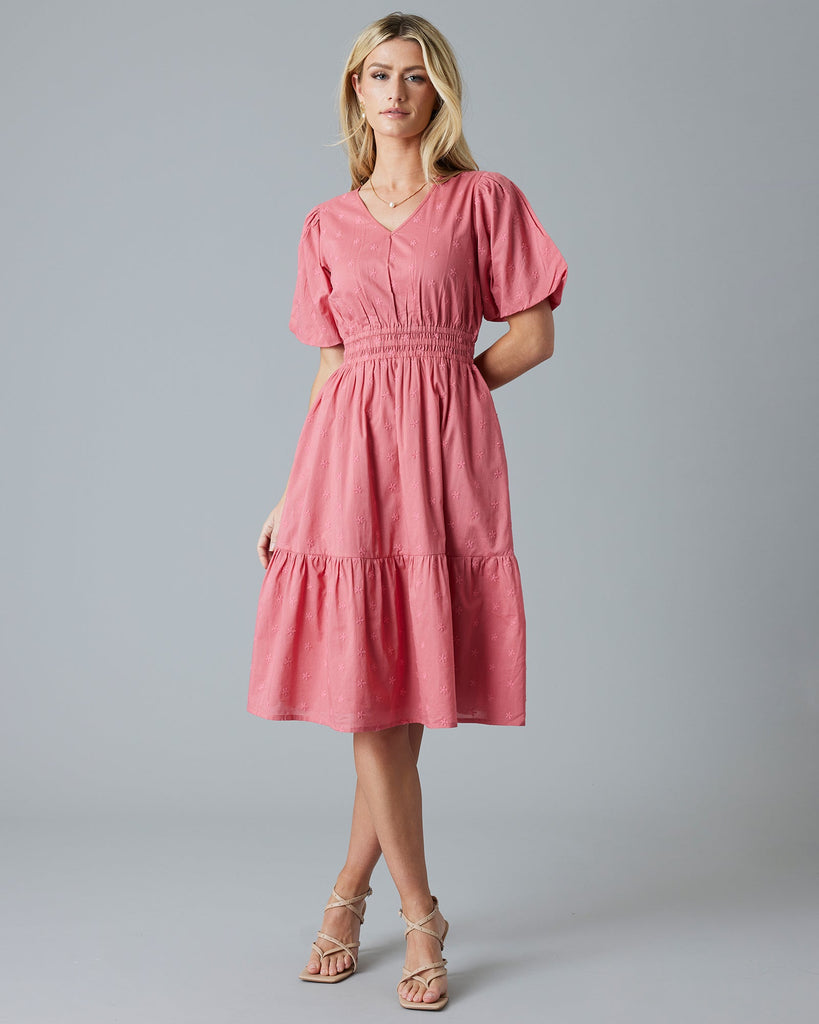 Woman in a rose color, embroidered, short sleeve knee-length dress