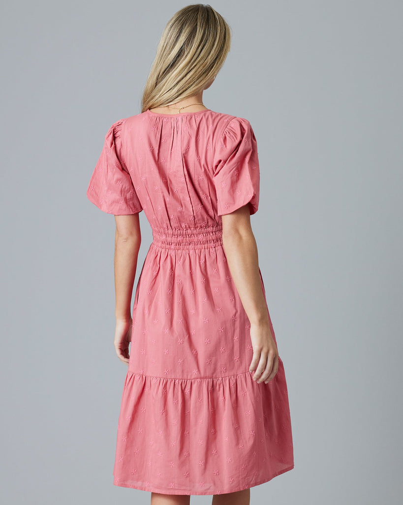 Woman in a rose color, embroidered, short sleeve knee-length dress