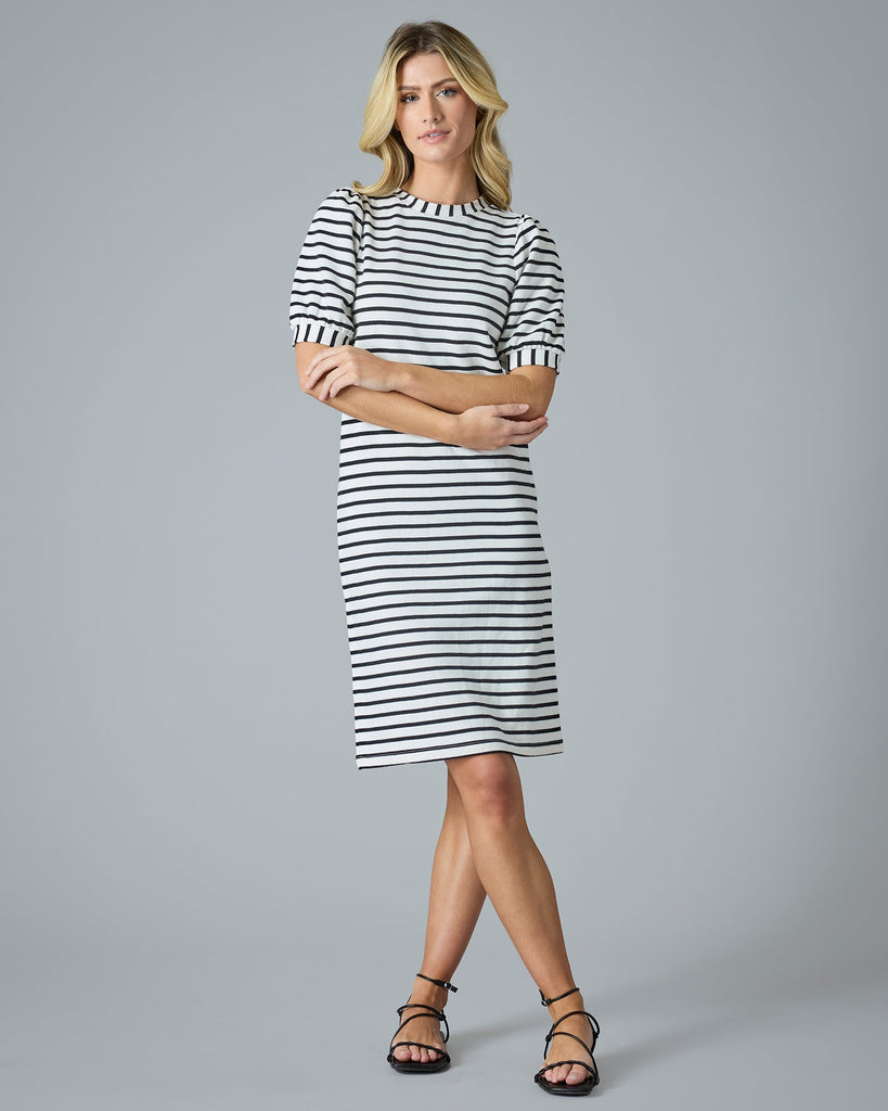 Woman in a short sleeve, navy and cream striped knee-length dress