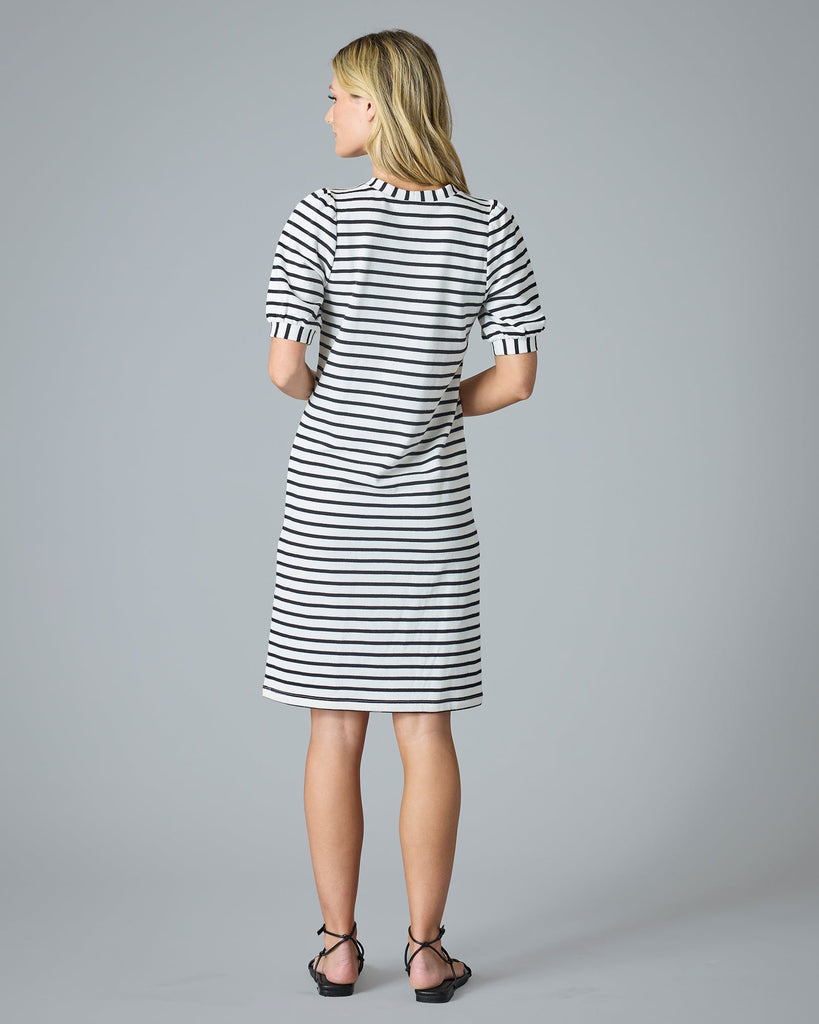 Woman in a short sleeve, navy and cream striped knee-length dress