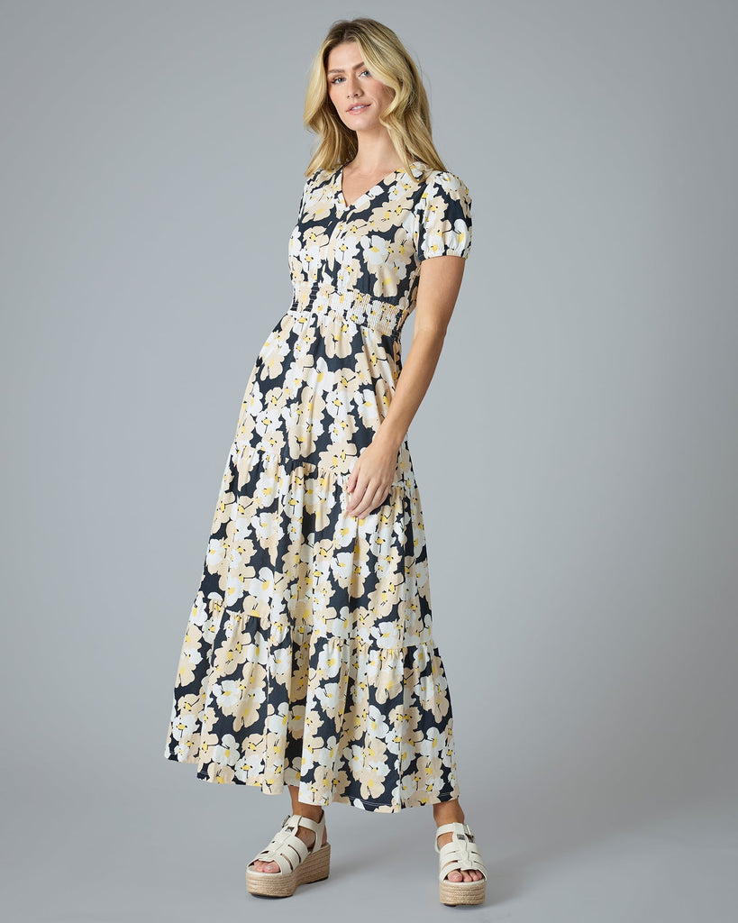 Woman in a navy, white and yellow floral printed short sleeve maxi dress