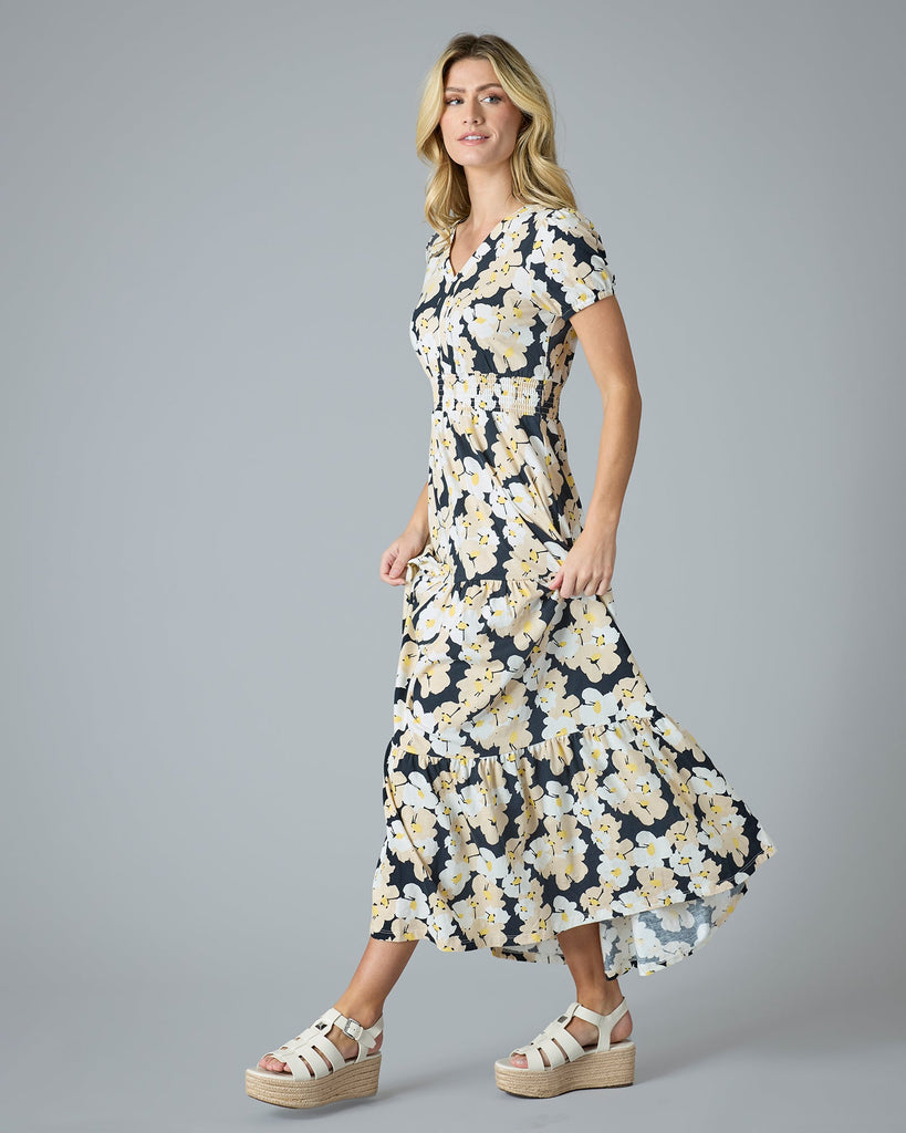 Woman in a navy, white and yellow floral printed short sleeve maxi dress