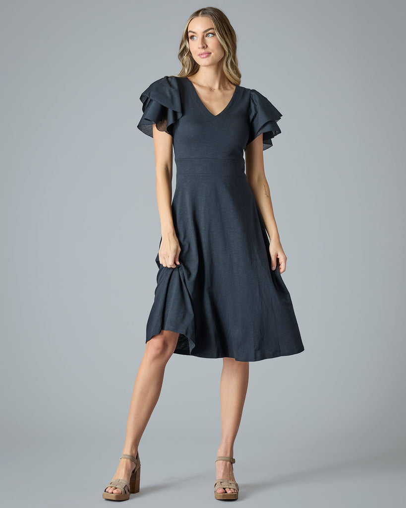 Woman in a black midi-length dress with ruffle short sleeves