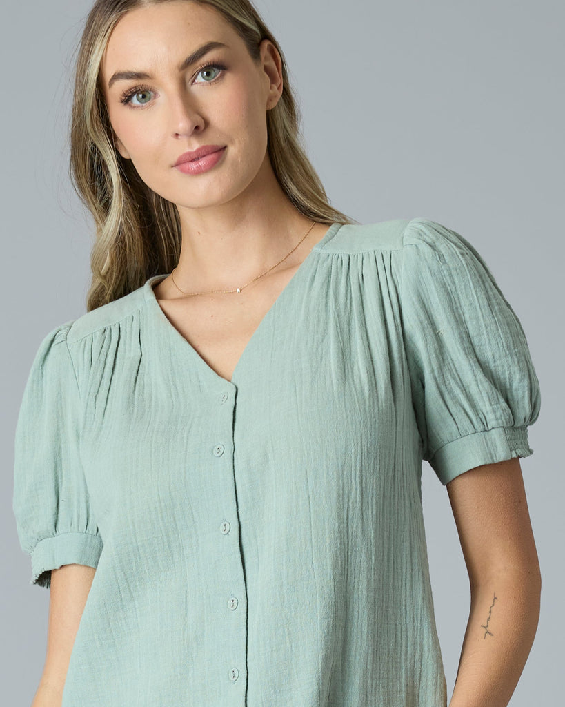 Woman in a green short sleeve button-down blouse