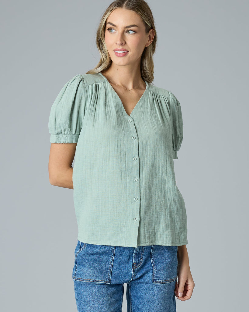 Woman in a green short sleeve button-down blouse