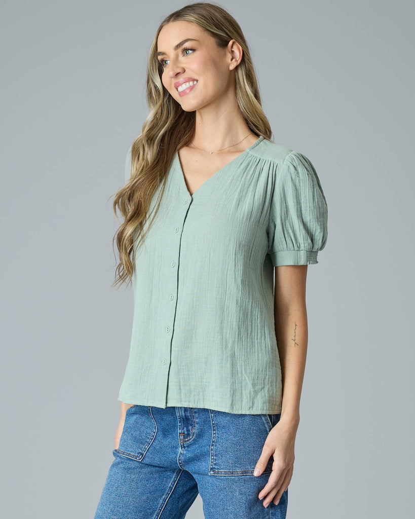 Woman in a green short sleeve button-down blouse