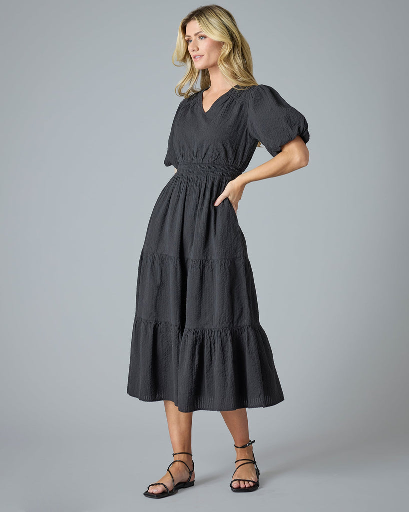 Woman in a black short sleeve midi-length dress