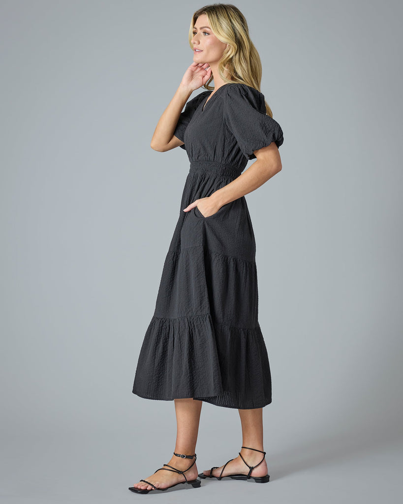 Woman in a black short sleeve midi-length dress