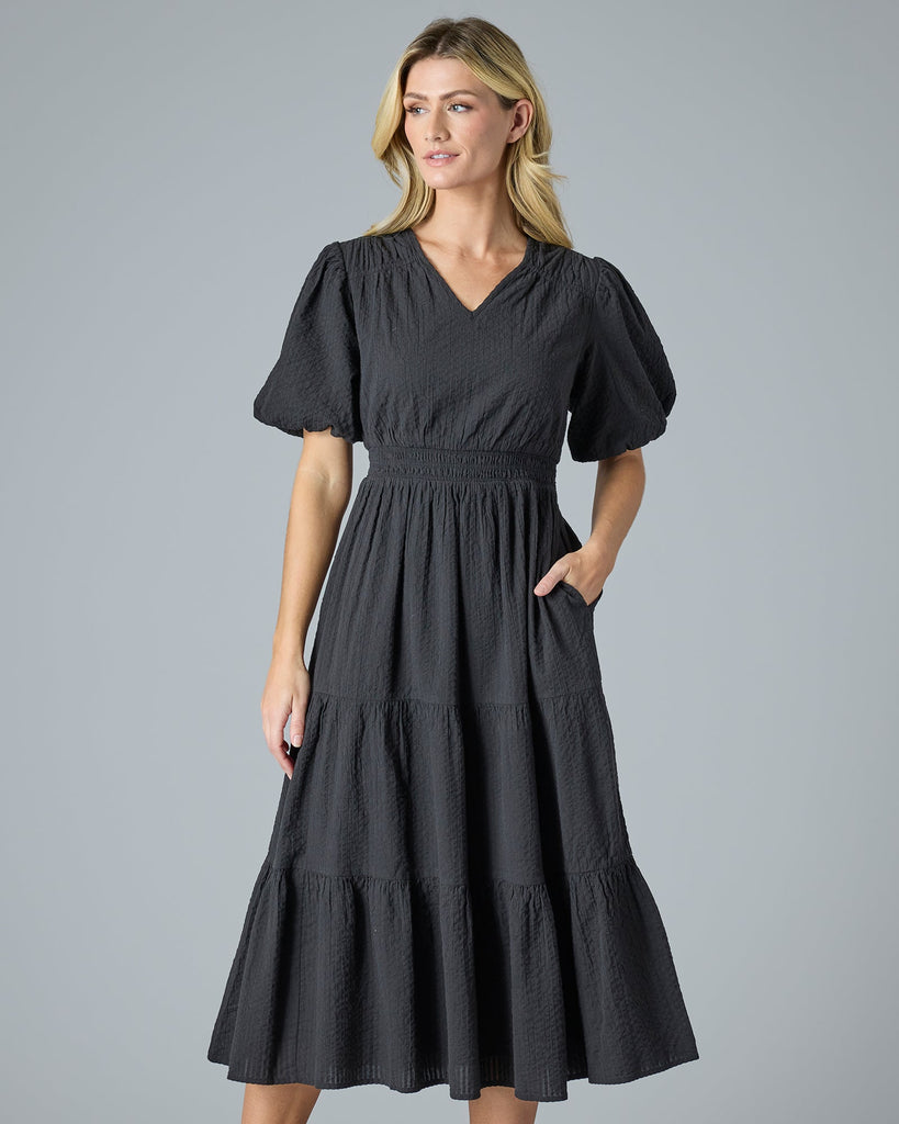 Woman in a black short sleeve midi-length dress