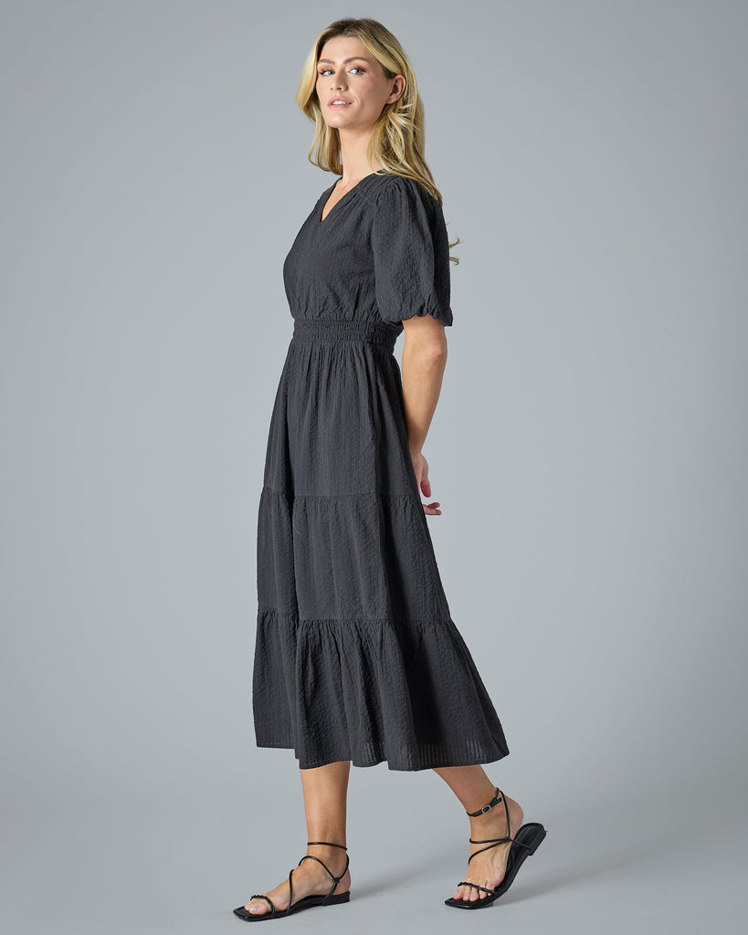 Woman in a black short sleeve midi-length dress