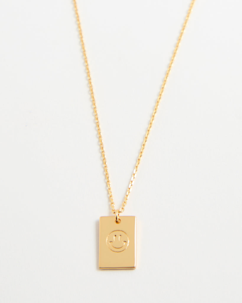 Gold necklace with smiley face pendant